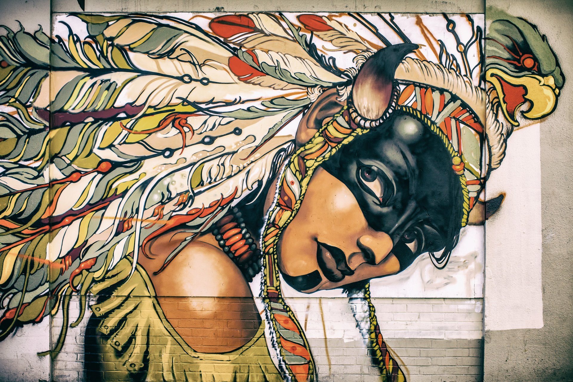 ragazza viso colorazione copricapo piume graffiti parete vernice