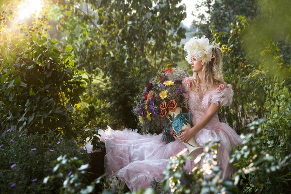 La ragazza si siede sulla natura con i fiori