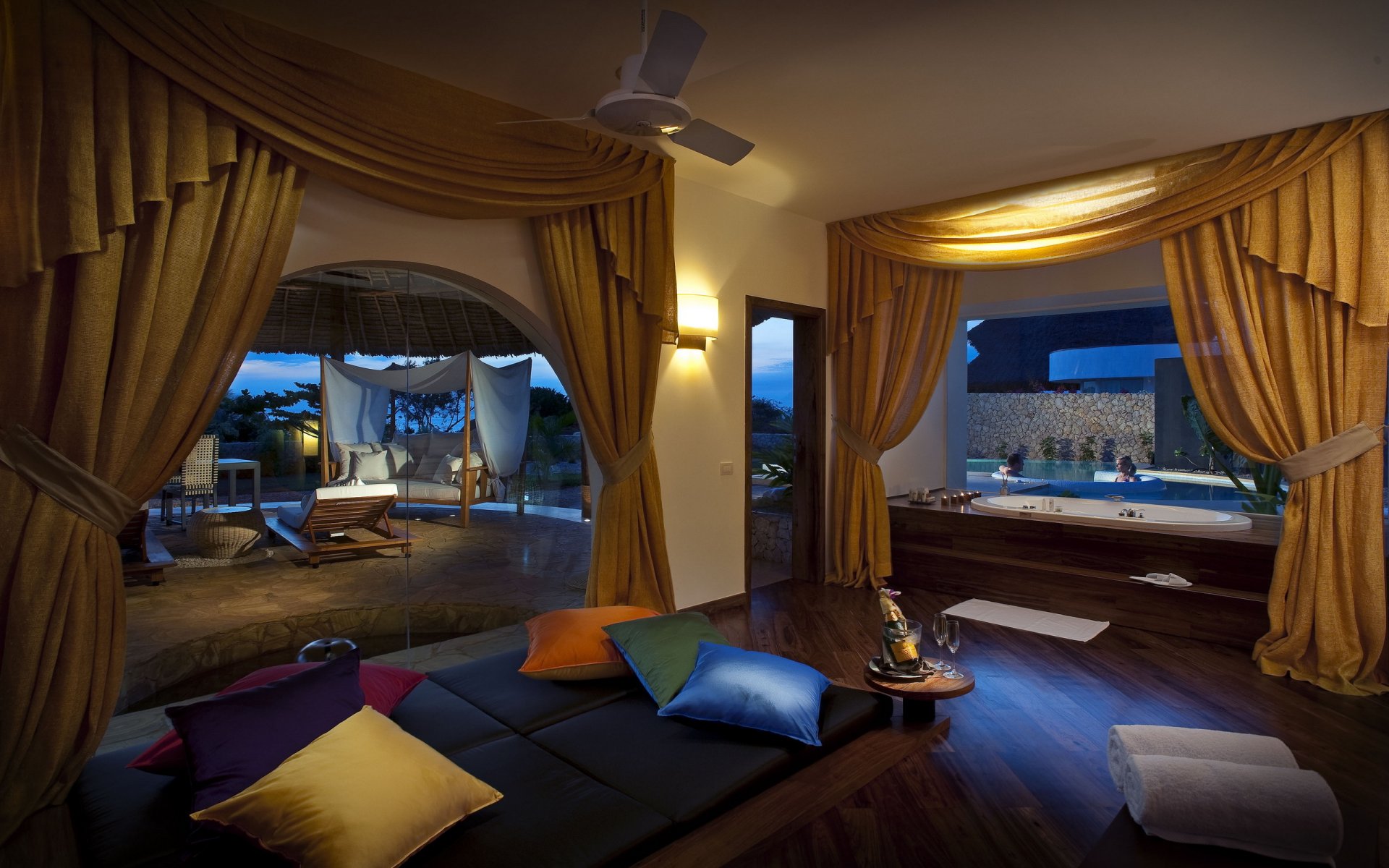 interni camera bagno tende giallo cuscini multicolori grandi finestre champagne piscina persone due vasca idromassaggio sera