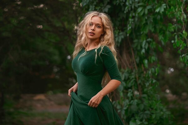 Ragazza in abito verde su sfondo fogliame