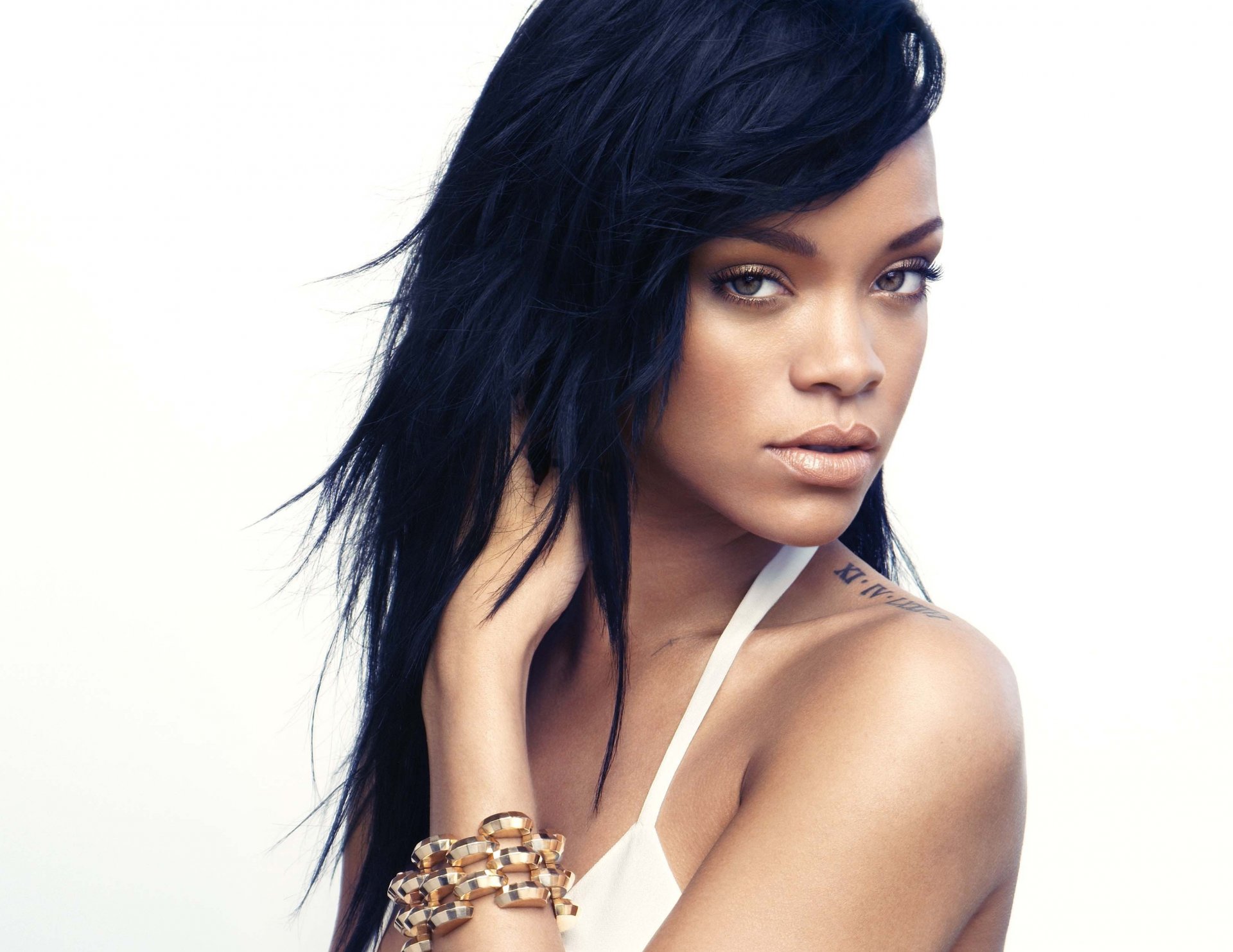rihanna cantante sguardo viso capelli tatuaggio bracciale sfondo bianco
