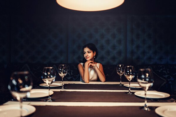 Ragazza bruna al tavolo con gli occhiali